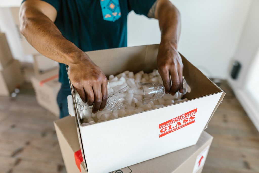 Person packing glasses inside a package box